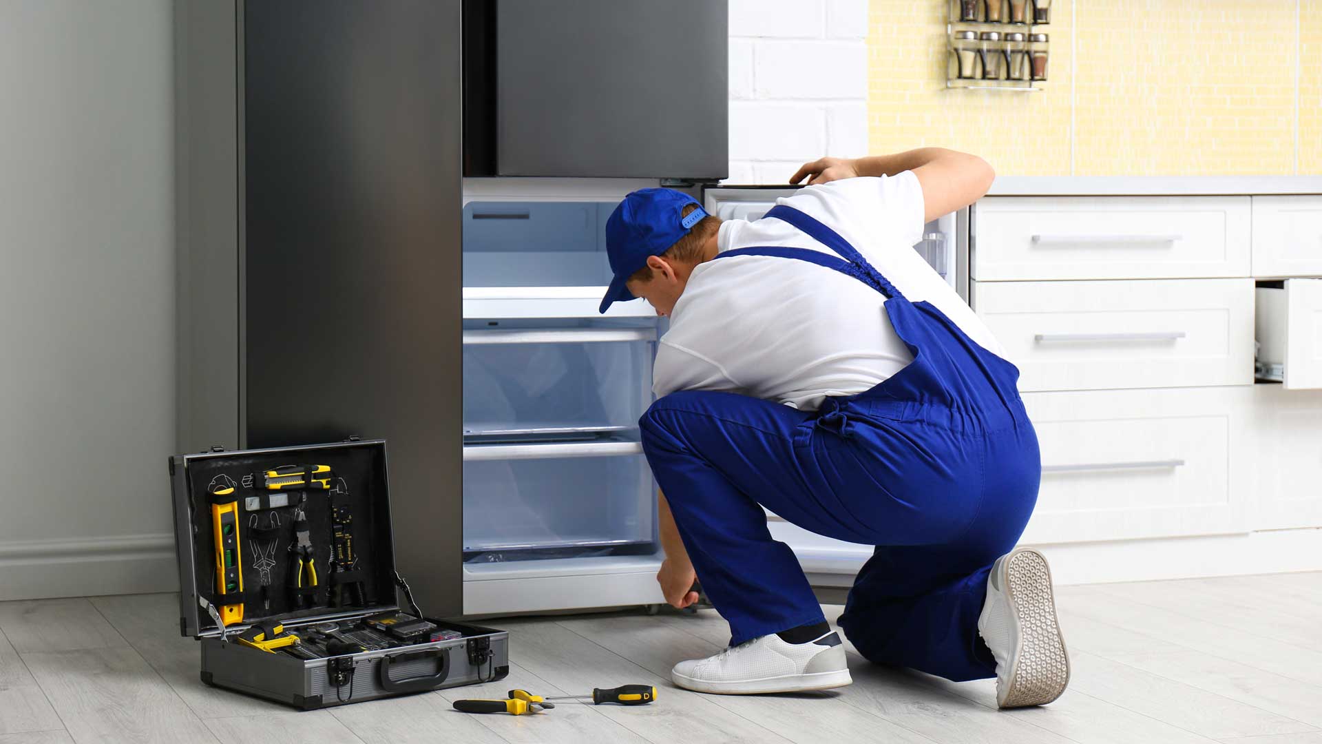 Technician repairs the freezer part of a refrigerator